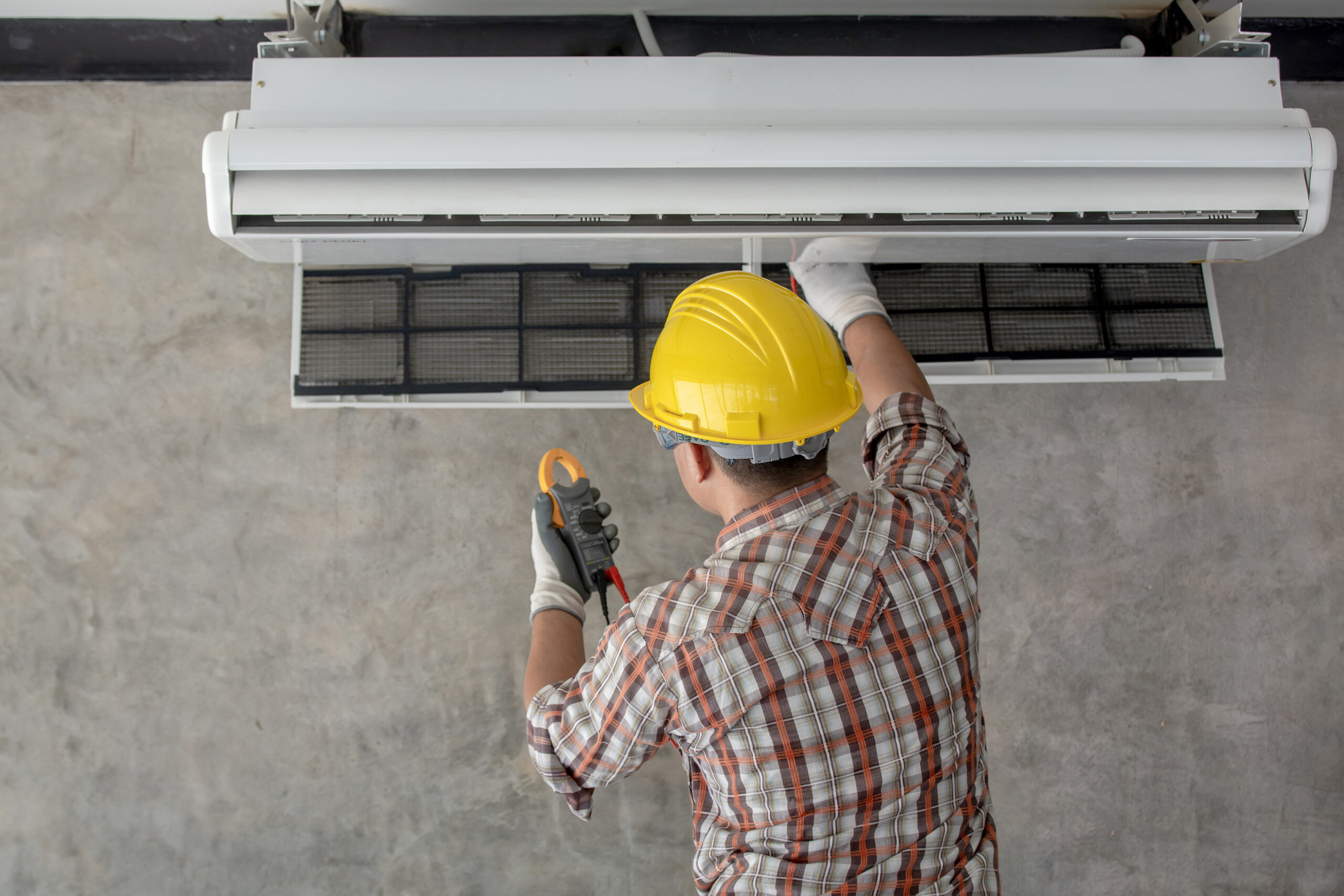 A technician in process of inspecting and maintaining an hvac ductless system.